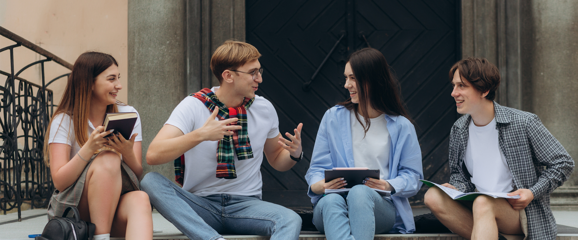 grupa młodych ludzi siedząca na schodach