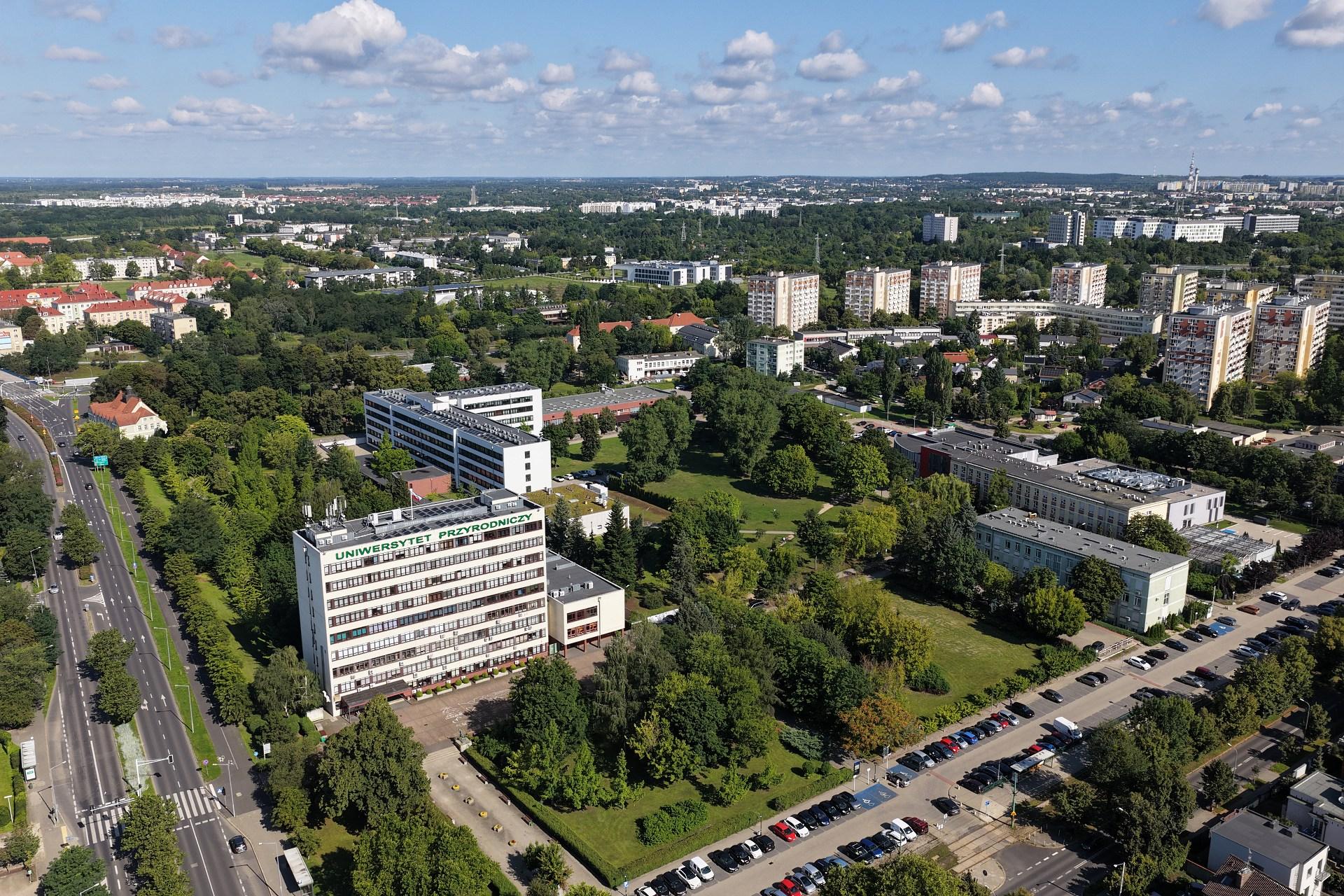 Aerial view of the PULS campus and Poznan, showcasing urban architecture and green spaces under a clear blue sky