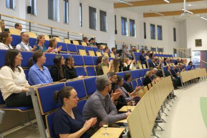 Grupa osób w sali wykładowej patrzy na ekran