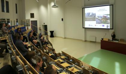 Grupa osób w sali wykładowej patrzy na ekran