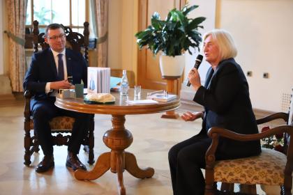 Dwie osoby przy okrągłym stole, podczas spotkania z Zofią Szalczyk