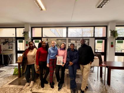 Grupa osób na korytarzu przegląda ubrania