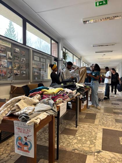 Grupa osób na korytarzu przegląda ubrania