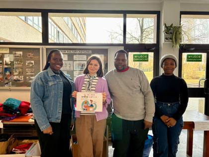 Grupa osób na korytarzu przegląda ubrania