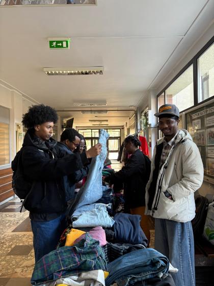 Grupa osób na korytarzu przegląda ubrania