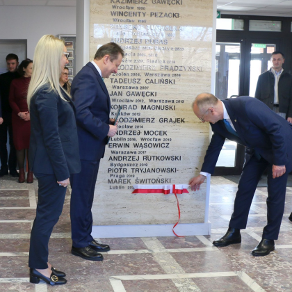 Grupa osób podczas odsłonięcia tablicy