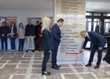 Grupa osób podczas odsłonięcia tablicy