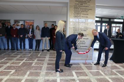 Grupa osób podczas odsłonięcia tablicy