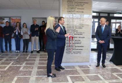 Grupa osób podczas odsłonięcia tablicy