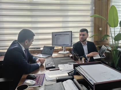 Dwóch mężczyzn siedzących przy biurku 