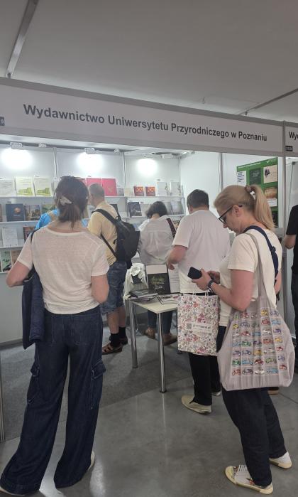 Grupa osób przy stoisku wystawienniczym