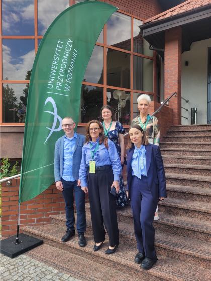 grupa osób przed budynkiem na schodach