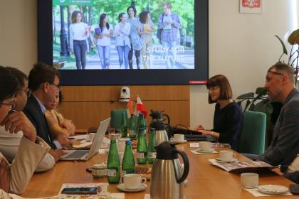 Grupa osób przy stole w sali konferencyjnej