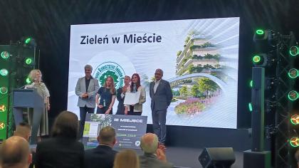 grupa osób na scenie podczas odbierania nagrody